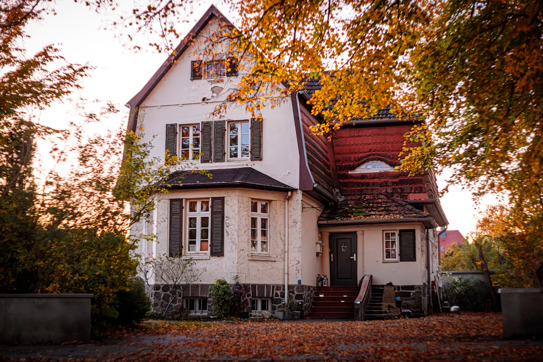 Haus und Garten im Herbst mit Laub und herbstlicher Bepflanzung